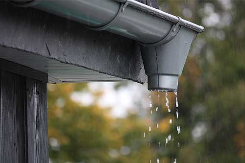 Newly installed seamless gutters along a residential roofline.